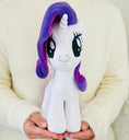 Load image into Gallery viewer, Plush toy unicorn with purple hair held by a person wearing a white sweater.