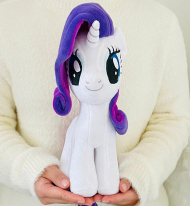 Load image into Gallery viewer, Plush toy unicorn with purple hair held by a person wearing a white sweater.