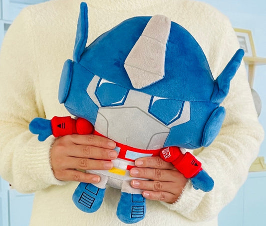 Person holding a blue and red robot plush toy against a light background