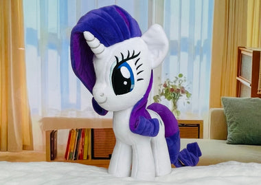 Load image into Gallery viewer, Plush toy unicorn with purple hair and tail in a room with curtains and books.