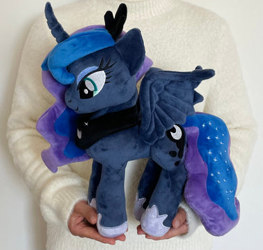 Load image into Gallery viewer, Plush toy of a dark blue pony with purple hair and wings on a white background