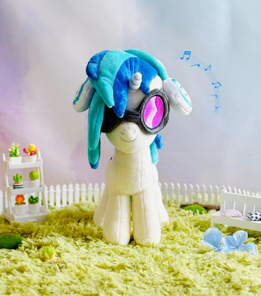 Load image into Gallery viewer, Plush toy with blue hair and goggles on a grassy area with a blurred background