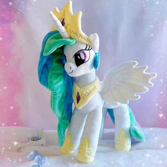 Plush toy unicorn with green hair and a crown on a gradient background