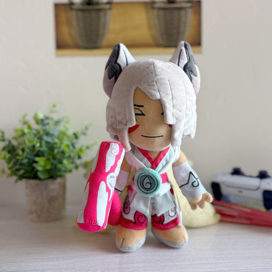 Plush toy with fox-like design on a surface with a plant and camera in the background