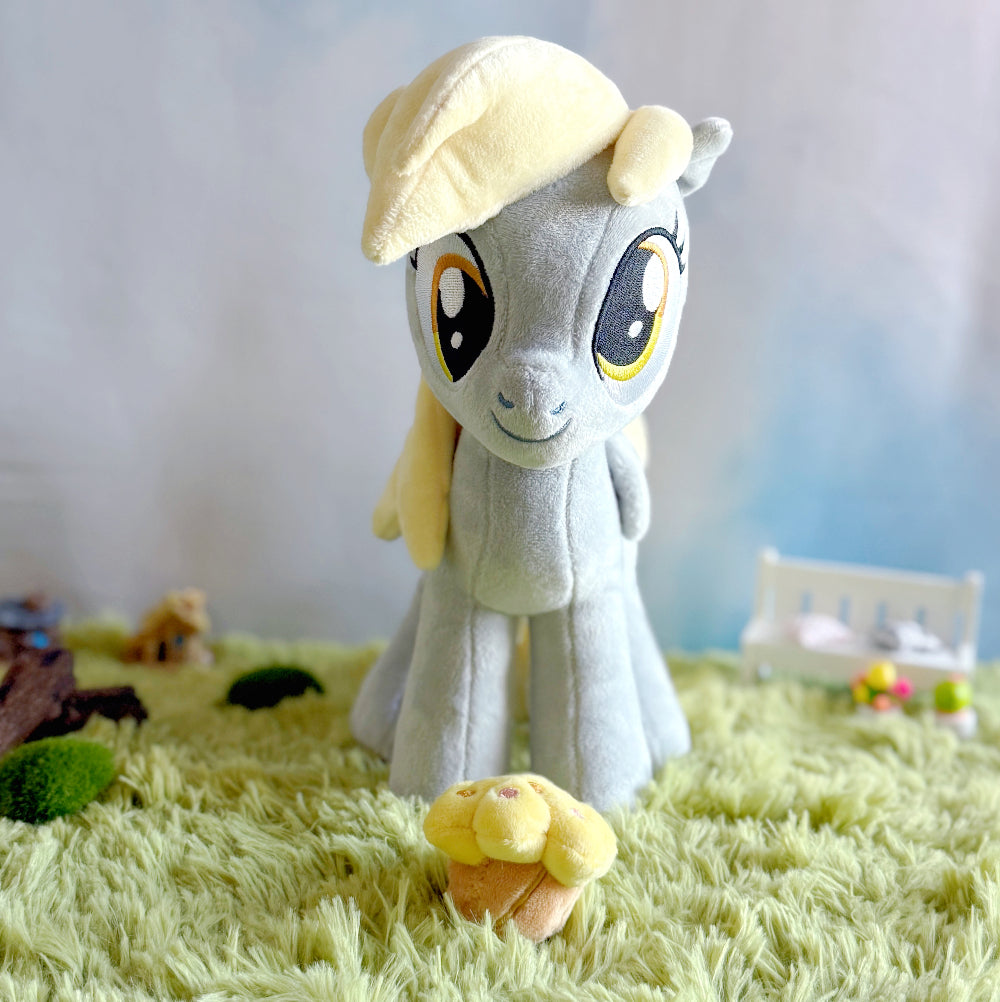 Plush toy with a yellow hat on a grass-like surface with a blurred background