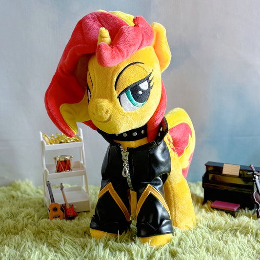 Plush toy of a stylized character with red and yellow hair on a grass-like surface.