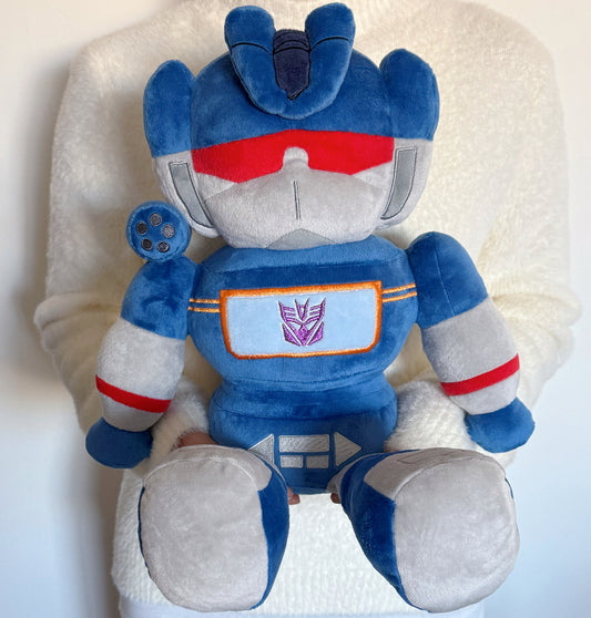 Plush toy robot with blue, gray, and red colors on a white background