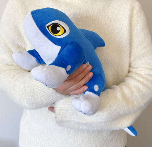 Person holding a blue plush shark toy against a white background