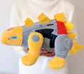 Load image into Gallery viewer, Plush toy resembling a robot dinosaur held by a person wearing a white robe.