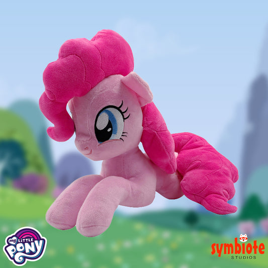 Pink plush toy with a blurred outdoor background, featuring 'My Little Pony' and 'symbiote STUDIOS' logos.