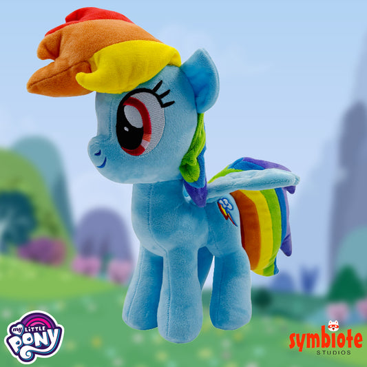 Plush toy of a blue pony with a rainbow hat and tail, set against a blurred outdoor background.