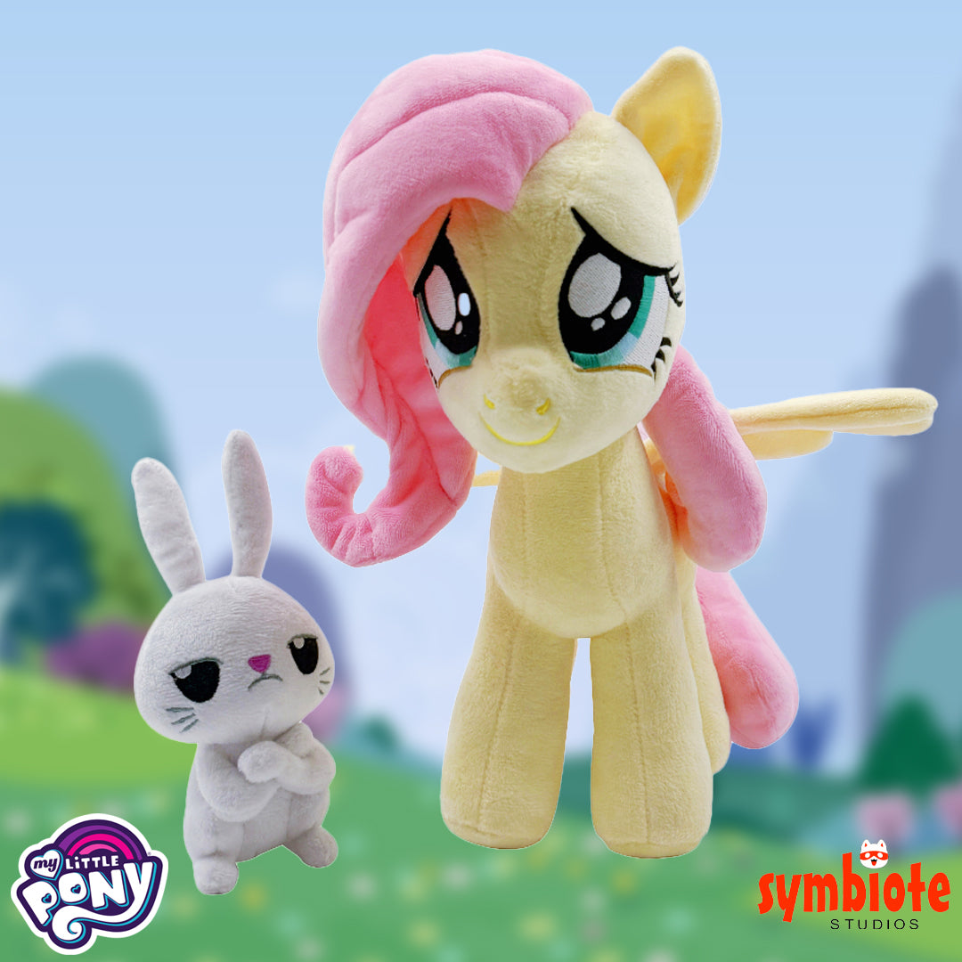 Plush toys of a pony and a rabbit with 'My Little Pony' and 'symbiote STUDIOS' logos.